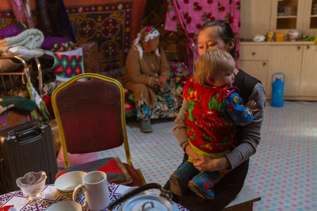BAYAN-OLGII, MONGOLIA - SEP 28, 2017: Kazakhs family of hunters with hunting golden eagles inside their the mongolian Yurts. In Bayan-Olgii Province is populated to 88,7% by Kazakhs.のeditorial素材