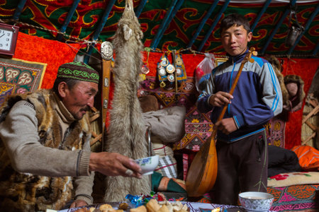 BAYAN-OLGII, MONGOLIA - SEP 28, 2017: Kazakhs family of hunters with hunting golden eagles inside their the mongolian Yurts. In Bayan-Olgii Province is populated to 88,7% by Kazakhs.のeditorial素材