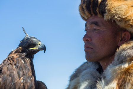 BAYAN-ULGII, MONGOLIA - SEP 30, 2017: Kazakh Eagle Hunter traditional clothing, while hunting to the...