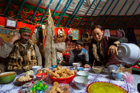 BAYAN-OLGII, MONGOLIA - SEP 28, 2017: Kazakhs family of hunters with hunting golden eagles inside their the mongolian Yurts. In Bayan-Olgii Province is populated to 88,7% by Kazakhs.のeditorial素材