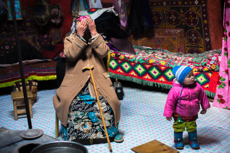 BAYAN-OLGII, MONGOLIA - SEP 28, 2017: Kazakh family of hunters with hunting birds (golden eagles) inside the mongolian Yurt. In Bayan-Olgii Province is populated mainly by Kazakhs (88,7 %)のeditorial素材