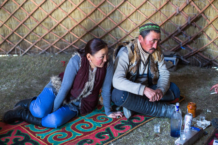 SAGSAI, BAYAN-OLGIY, MONGOLIA - SEP 28, 2017: Kazakh family of hunters with golden eagles inside the mongolian Yurt. In Bayan-Olgii Province is populated mainly by Kazakhs (88,7%)のeditorial素材