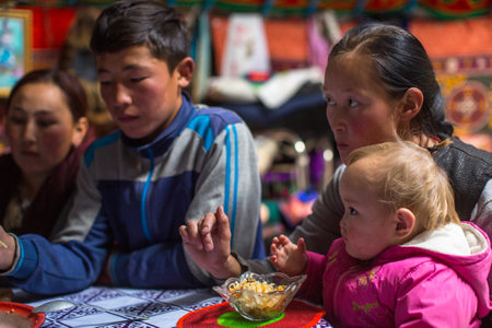 SAGSAI, BAYAN-OLGIY, MONGOLIA - SEP 28, 2017: Kazakh family of hunters with golden eagles inside the mongolian Yurt. In Bayan-Olgii Province is populated mainly by Kazakhs (88,7%)のeditorial素材