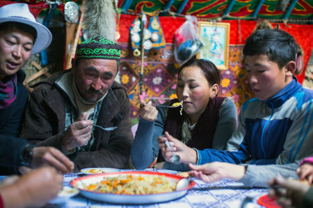 SAGSAI, BAYAN-OLGIY, MONGOLIA - SEP 28, 2017: Kazakh family of hunters with golden eagles inside the mongolian Yurt. In Bayan-Olgii Province is populated mainly by Kazakhs (88,7%)のeditorial素材