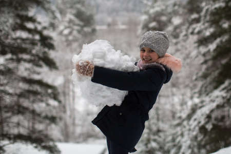 Little cute girl sculpts snowman.の写真素材