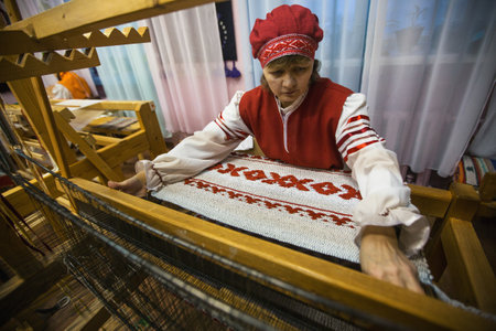 VAZHINY, LENINGRAD REGION, RUSSIA - DEC 21, 2017: Weaver while working in the Textile Studio of decorative art "Tekstilnaya Plastika", at municipal budgetary institution of culture.のeditorial素材