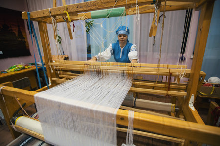 VAZHINY, LENINGRAD REGION, RUSSIA - DEC 21, 2017: Weaver while working in the Textile Studio of decorative art "Tekstilnaya Plastika", at municipal budgetary institution of culture.のeditorial素材