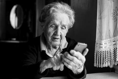 Elderly woman typing on the smartphone.の写真素材