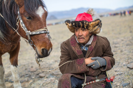 BAYAN-ULGII, MONGOLIA - SEP 30, 2017: Kazakh Eagle Hunter traditional clothing in desert mountain of Western Mongolia.のeditorial素材