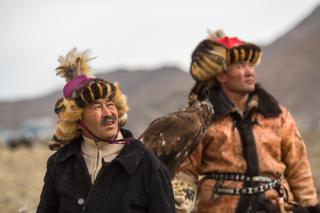 OLGIY, MONGOLIA - SEP 30, 2017: Eagle Hunter at traditional clothing, with a golden eagle on his arm...