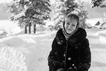 Black and white portrait of young russian woman in the winter on the snowy village. の写真素材