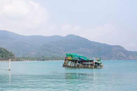 KO CHANG, THAILAND - FEB 15, 2018: Sunken ship near pier of Bang Bao fishing village, which consists of houses on stilts built into the sea.のeditorial素材