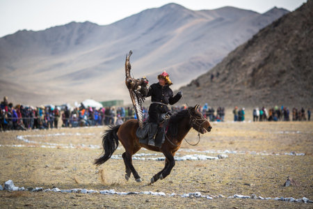 OLGIY, MONGOLIA - SEP 30, 2017: Eagle Hunter at traditional clothing, with a golden eagle on his arm during annual national competition with birds of prey BERKUTCHI of West Mongolia.のeditorial素材