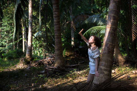 Young beautiful asian girl in a tropical jungle.の写真素材