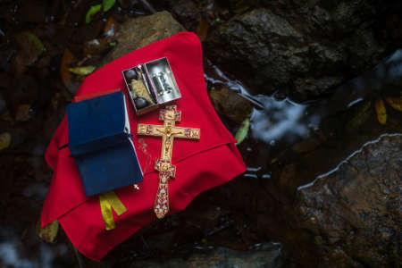 Holy Bible and the Orthodox Cross during the sacrament of baptism outdoors. の写真素材