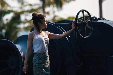 Young beautiful mixed race woman stands on an abandoned giant ship.