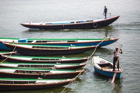VARANASI, INDIA - MAR 13, 2018: Boatmen on the banks of Ganga river. Varanasi is one of the most...