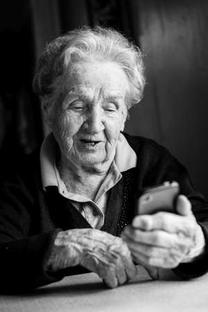 Elderly woman typing on the smartphone.の写真素材
