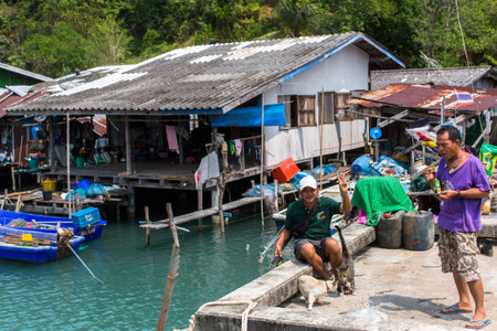 KOH CHANG, THAILAND - FEB 17, 2018: Locals of Fishing village on the Eastern shore, which consists of houses on stilts built into the sea. Island consisting of 8 villages with 5,356 inhabitants.のeditorial素材