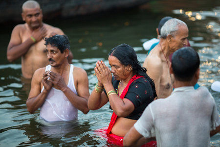 VARANASI, INDIA - MAR 23, 2018: Pilgrims plunge into the water holy Ganges river in the early morning. According to legends, the city was founded by God Shiva about 5000 years ago.のeditorial素材
