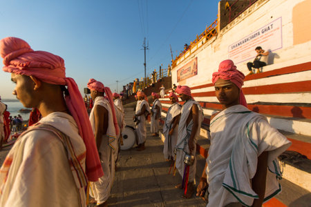 VARANASI, INDIA - MAR 18, 2018: Young hindu monks conduct a ceremony to meet the dawn on the banks of the Ganges, and raise the Indian flag. Varanasi is one of the 7 sacred cities of Hinduism.のeditorial素材