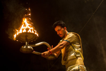 VARANASI, INDIA - MAR 23, 2018: Hindu priests perform Agni Pooja (Sanskrit: Worship of Fire) on...