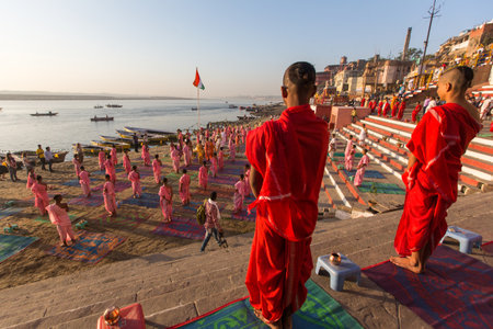 VARANASI, INDIA - MAR 18, 2018: Young hindu monks conduct a ceremony to meet the dawn on the banks of the Ganges, and raise the Indian flag. Varanasi is one of the 7 sacred cities of Hinduism.のeditorial素材