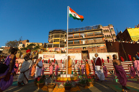 VARANASI, INDIA - MAR 18, 2018: Young hindu monks conduct a ceremony to meet the dawn on the banks...