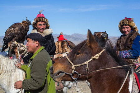 OLGIY, MONGOLIA - SEP 30, 2017: Golden Eagle Hunters at traditional clothing, with a golden eagle on...