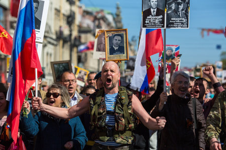 ST. PETERSBURG, RUSSIA - MAY 9, 2018: People hold flags and pictures of World War Two soldiers as...
