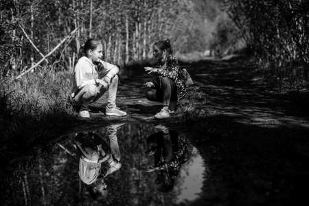 Two girls sisters or  girlfriends are talking emotionally in the Park. Black and white photo.の写真素材