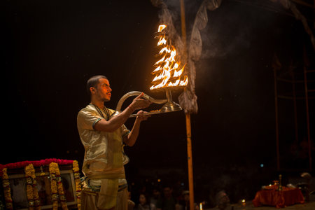 VARANASI, INDIA - MAR 15, 2018: A group of priests perform Agni Pooja (Sanskrit: Worship of Fire) on Dashashwamedh Ghat - main and oldest ghat of Varanasi located on the Ganges.のeditorial素材