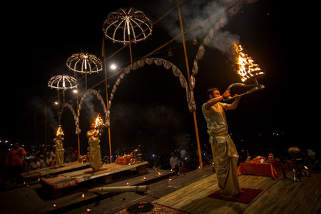 VARANASI, INDIA - MAR 15, 2018: A group of priests perform Agni Pooja (Sanskrit: Worship of Fire) on Dashashwamedh Ghat - main and oldest ghat of Varanasi located on the Ganges.のeditorial素材
