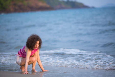 Mixed race woman on a tropical beach.の写真素材