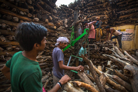 VARANASI, INDIA - MAR 22, 2018: Locals near Holy Ganges weighed for sale wood for cremation. Manikarnika Ghat is one of the ghats in Varanasi and is most known for being a place of Hindu cremation.のeditorial素材