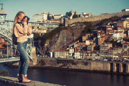 Girl taking pictures of Douro river, in the center of Porto, Portugal.の写真素材