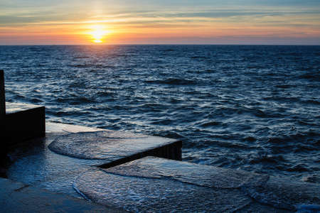 Atlantic sunset at the stone pier in calm weather.の写真素材