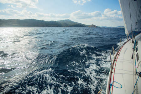 Sailing yacht glides on the sea, the waves come from under the boat.