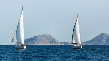 Sailing luxury boats participate in sail yacht regatta in the Aegean Sea in Greece.