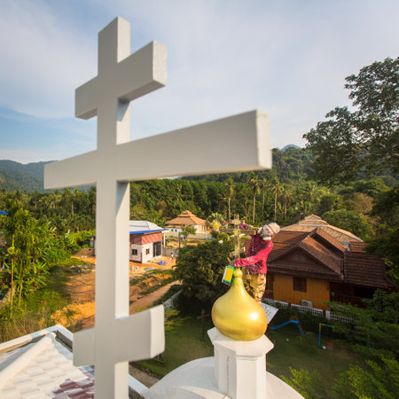KOH CHANG, THAILAND - FEB 24, 2018: Orthodox Priest refreshes crosses on domes of the church. There are currently 10 Orthodox parishes in Thailand and Orthodoxy is practiced by 0.002% of population.のeditorial素材