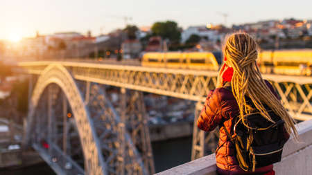 Woman with gold dreadlocks opposite the Dom Luis I bridge in Porto - Portugal.の写真素材
