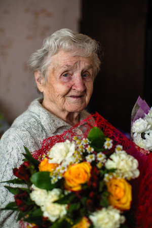 An old woman with a bouquet of flowers.