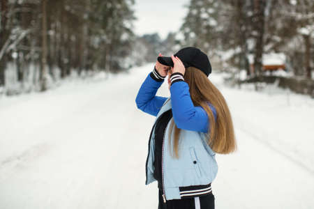 Teen girl in the park in snowy winter.の写真素材