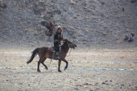 SAGSAY, MONGOLIA - SEP 30, 2017: Berkutchi - Kazakh hunter with Golden eagle, while hunting to the hare in desert mountain of Western Mongolia.のeditorial素材