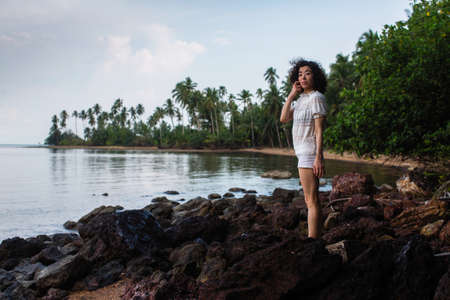 Young asian woman on the coast of a tropical sea beach.の写真素材
