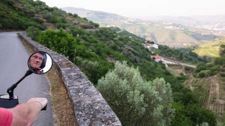 Motorcyclist rides on a serpentine road of the Douro Valley, Porto, Portugal.の写真素材