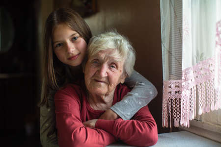 Portrait of little girl and her old great-grandmother.