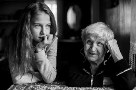 Grandmother talking with her granddaughter, black-and-white photo.