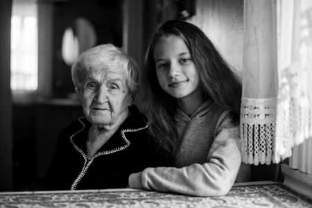 Little cute girl with a grandmother in the house black and white portrait.