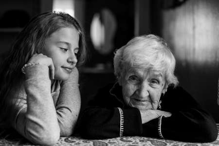 An elderly grandmother with her little granddaughter. Portrait black and white.の写真素材